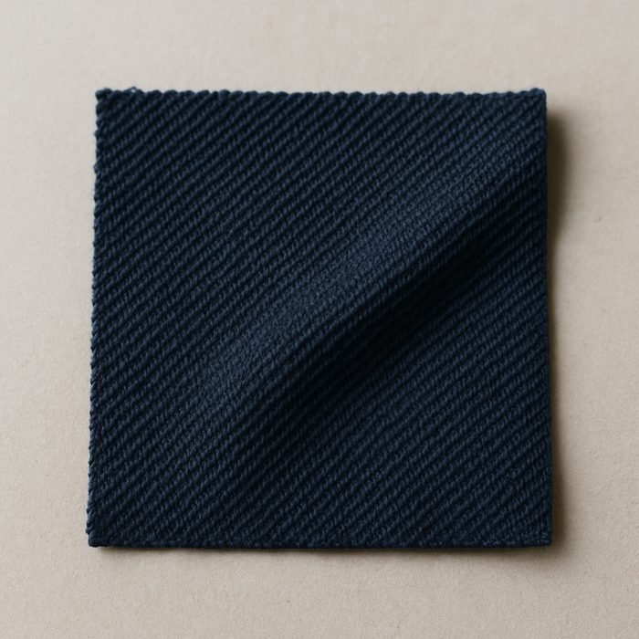 Close-up of navy cotton pique knit showing its raised waffle texture